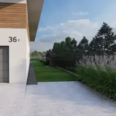 Piękne trawy ozdobne przy ogrodzeniu, obok nowoczesnego domu z garażem.